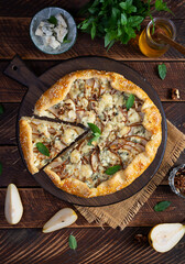 Homemade pear brie galette on wooden board, golden crust, melted cheese, honey glaze. Sliced galette with pear and bri cheese