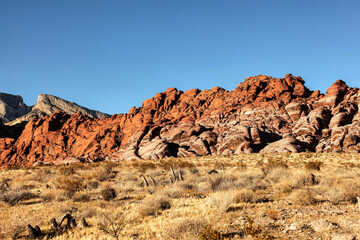 Vibrant Red Sandstone Peaks Rise Majestically Against Azure Skies in Red Rock Canyon's Ancient Desert Embrace, Nevada