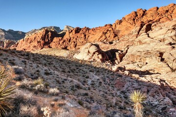 Vibrant Red Sandstone Peaks Rise Majestically Against Azure Skies in Red Rock Canyon's Ancient Desert Embrace, Nevada