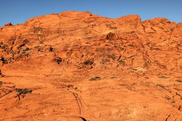 Vibrant Red Sandstone Peaks Rise Majestically Against Azure Skies in Red Rock Canyon's Ancient Desert Embrace, Nevada