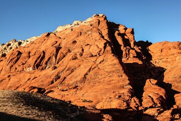 Vibrant Red Sandstone Peaks Rise Majestically Against Azure Skies in Red Rock Canyon's Ancient Desert Embrace, Nevada