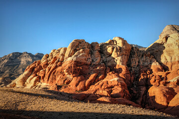 Vibrant Red Sandstone Peaks Rise Majestically Against Azure Skies in Red Rock Canyon's Ancient Desert Embrace, Nevada