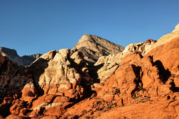 Vibrant Red Sandstone Peaks Rise Majestically Against Azure Skies in Red Rock Canyon's Ancient Desert Embrace, Nevada