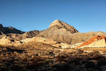 Vibrant Red Sandstone Peaks Rise Majestically Against Azure Skies in Red Rock Canyon's Ancient Desert Embrace, Nevada