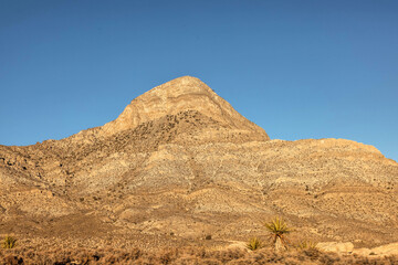 Vibrant Red Sandstone Peaks Rise Majestically Against Azure Skies in Red Rock Canyon's Ancient Desert Embrace, Nevada