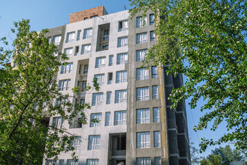 Construction work on the exterior cladding. Laying of thermal insulation material on the walls. Home insulation. Plastering the walls. Windows of a multi-storey house under construction.
