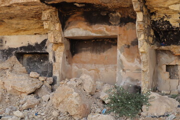 Mountain house carved into solid rock in Aleppo, Syria, damaged by war with burn, erosion, and visible destruction marks. A powerful symbol of survival and the lasting harsh impact of conflict.