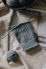 Close up of hand knitting with needles and yarn ball. Concept for handmade and hygge slow life.