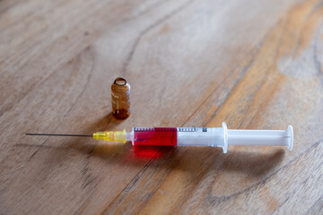 Aufgezogene Spritze mit rotem Serum 
