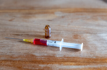 Aufgezogene Spritze mit rotem Serum 