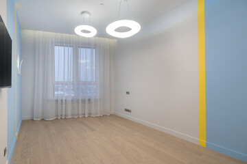 Modern empty room with blue and yellow accents, bright lighting, and wooden floor in a contemporary apartment