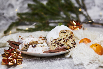 Aesthetic Christmas dinner. Christmas stollen, chocolate, tangerines and Christmas decorations. Christmas tradition, festive bokeh background