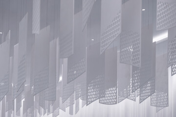 a series of geometric, lattice-patterned paper lanterns hanging from the ceiling. The lanterns are...