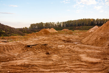 Expansive sand quarry with numerous towering sand piles and fresh excavations. A vast construction...