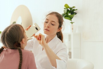 Teenage girl is listening to doctor during medical examination in modern clinic. Concept of medicine and healthcare. Part of a series. Close up