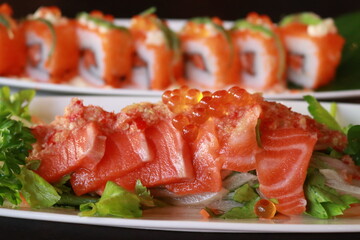 A mouthwatering plate of sushi, featuring salmon sashimi and sushi rolls. The image showcases the fresh ingredients and vibrant colors of the dish.