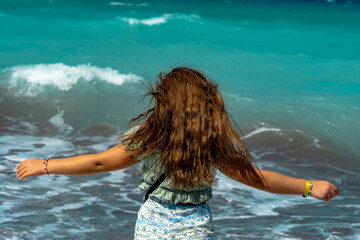 Little girl with outstretched arms against the Aegean Sea