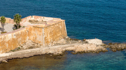 Aerial closeup of Torrino Conca. It's a medieval defensive tower located in the historic center of Trapani, Sicily, Italy. It overlooks the Mediterranean Sea.