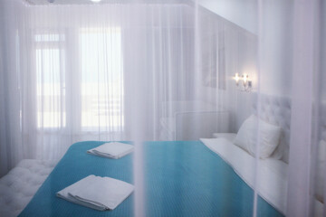 Four-poster bed. A cozy bedroom in bright colors. The concept of recreation.