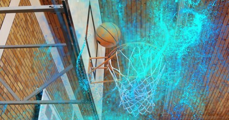 Descending basketball passing through orange rim and net in gym, with turquoise particle swirl