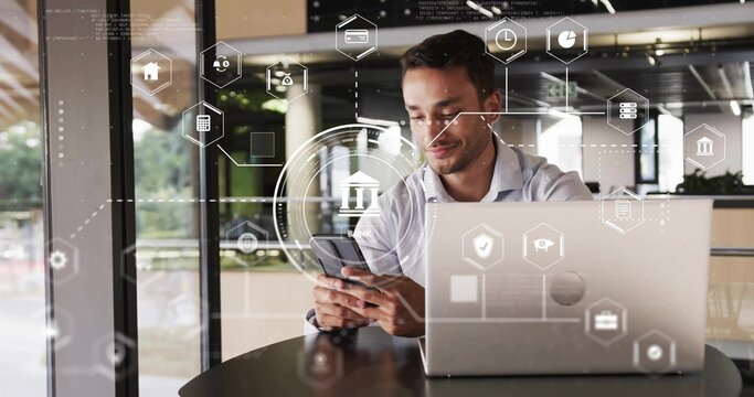 Analyzing fintech icons man in shirt using smartphone at table in office, with laptop, copy space