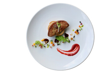 Gourmet plate presentation of foie gras with garnish. The foie gras is placed on top of a bread and is presented with colorful sauces and vegetables