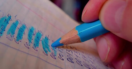 Close-up shot of hand coloring numbers on paper with blue pencil, emphasizing precision and focus in paperwork