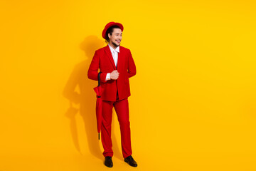 Funny bold fashion moment with a stylish man in a red suit posing against a bright yellow background for a playful holiday themed business style