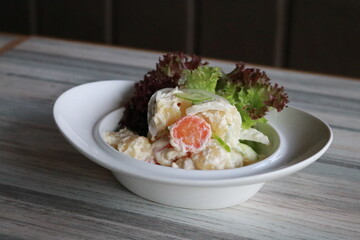 A refreshing salad beautifully presented in an elegant bowl on a table. The vibrant colors and fresh ingredients create an appetizing and healthy meal. 