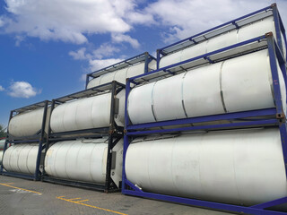 Isotank container stack in an logistic freight area, showing rows of stainless steel tanks arranged in layers for chemical and liquid transport logistics. 