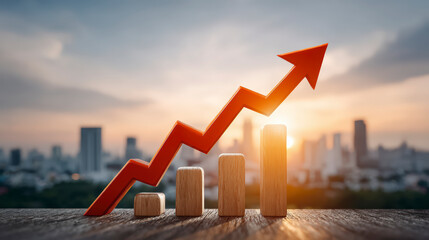 A rising arrow above wooden blocks representing growth against a sunset cityscape backdrop, symbolizing economic or business improvement.