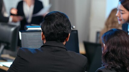 A diverse team of software developers examining computer code on a monitor, focusing on debugging or code review. Mentorship, technical training. Developing application program, Cybersecurity center - Powered by Adobe