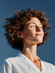 Woman enjoying sunshine feeling peaceful wellbeing outdoors
