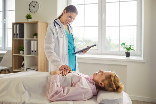 Doctor offers support at the hospital bedside holding a patients hand and reviewing a tablet to guide care and build trust during recovery. Doctor comforts patient during bedside consultation.
