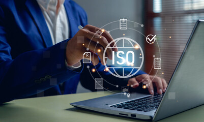 business professional working laptop with glowing ISO certification icons, symbolizing...