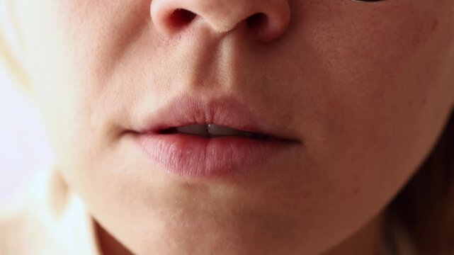 Close-up of female mouth chattering teeth, showing fear and cold.