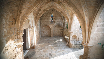 Sunlight illuminating stone arches and floor in Bellapais Abbey. Kyrenia District, Cyprus