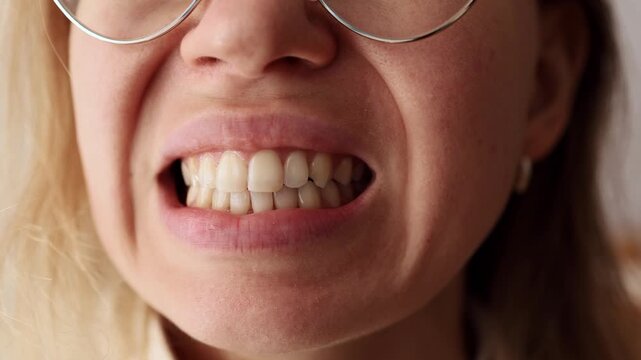 Close-up of female mouth baring teeth, showing anger and emotion.