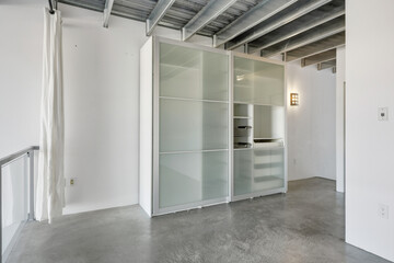 Large white closet with glass doors and a mirror
