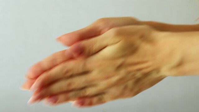 Female hands rubbing palms together, showing warmth or preparation.