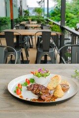 A close-up of a delectable steak dish beautifully presented on a wooden table. The plate includes a grilled steak, a fresh salad, and bread