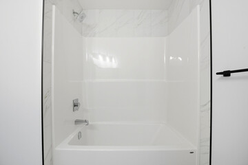 White bathroom with a white bathtub and a white shower
