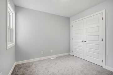 White room with a white door and a window