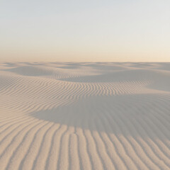 Obraz premium Dramatic golden desert sand dunes stretch across the hot landscape under a vast dry sky, suggesting an adventure in the Sahara