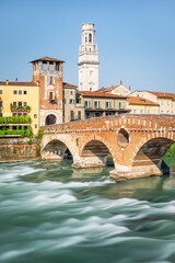 Obraz premium Die römische Ponte Pietra über dem Fluß Etsch mit dem Panorama der Altstadt von Verona in der Morgensonne, Venetien, Italien