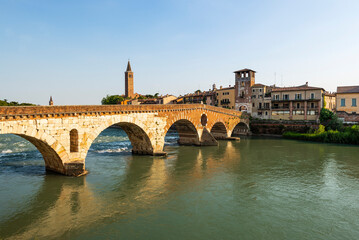 Die römische Ponte Pietra über dem Fluß Etsch in der Altstadt von Verona leuchtet in der Abendsonne, Venetien, Italien