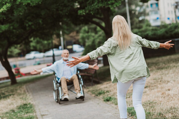 Joyful park reunion with family care and love as a woman welcomes a grandfather in a wheelchair and old man smiles