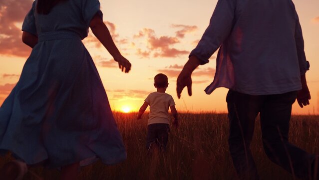 Dad mom child son play outside. Happy family, father mother kid, running on green grass in nature. Family run in nature park. Mom dad kid son having picnic in nature on weekend. Parents child playing - Powered by Adobe