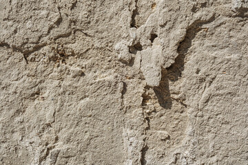 Cracked and weathered stone plaster wall for rustic building and texture background concept