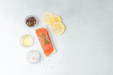 Fresh salmon fillet with herbs, spices, and lemon slices for cooking